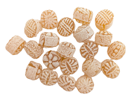 Runde, mit Zucker bestreute Ingwerbonbons mit Streifenmuster auf weißem Hintergrund