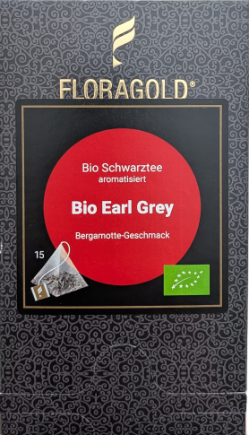 Eine quaderförmige Verpackung von FLORAGOLD Bio Earl Grey. Der Grundton ist dunkelgrau mit einem komplexen goldenen Ornamentmuster. Oben ein goldenes geflügeltes Logo und der goldene Schriftzug "FLORAGOLD". In der Mitte befindet sich ein schwarzes Quadrat
