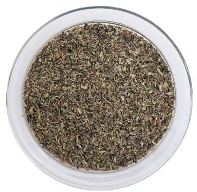 Draufsicht auf eine runde Glasschale vor weißem Hintergrund mit einer klassischen Kräuter-der-Provence-Mischung, bestehend aus fein gerebelten, olivgrünen Blättchen und vereinzelt zart violetten Lavendelblüten.