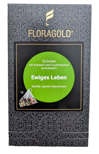 Die Verpackung von FLORAGOLD Grüntee "Ewiges Leben". Sie ist dunkelgrau mit einem goldenen Ornamentmuster. Oben ein goldenes geflügeltes Logo und der goldene Schriftzug "FLORAGOLD". Mittig ein schwarzes Quadrat mit einem grünen Kreis. Weißer Text darauf: