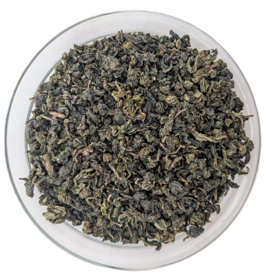 Oolong Ti Dung Tee – fest gerollte, oliven- bis dunkelgrüne Teeblätter in einer transparenten Schale aus der Vogelperspektive.