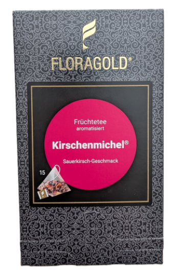 Eine dunkelgraue Verpackung von FLORAGOLD "Kirschenmichel" mit einem feinen Ornamentmuster. Oben befindet sich das goldene FLORAGOLD-Logo. In der Mitte zeigt ein schwarzer Rahmen einen leuchtend pink-roten Kreis mit der Aufschrift: "Früchtetee aromatisier