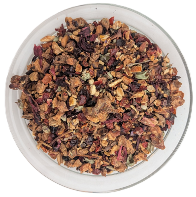 Grobe Früchteteemischung in einer runden Glasschale auf weißem Hintergrund, bestehend aus großen getrockneten Apfelstücken, roten Hibiskusblüten, Orangenschalen und dunklen Beeren.