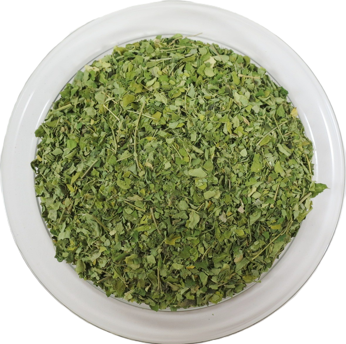 Eine runde Glasschale aus der Vogelperspektive, gefüllt mit fein geschnittenen, getrockneten Moringa-Blättern. Die gleichmäßig grünen Blattstücke haben eine zarte Textur.