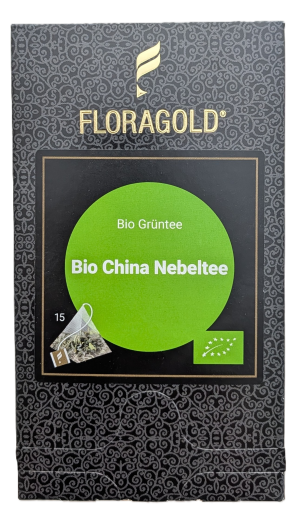 Eine dunkelgraue FLORAGOLD-Teeverpackung mit goldenem Schriftzug und Schwingen-Logo oben. Ein hellgrüner Kreis im zentralen schwarzen Rahmen trägt die Aufschrift "Bio Grüntee" und "Bio China Nebeltee". Unten rechts ist das grüne EU-Bio-Siegel zu sehen. Un