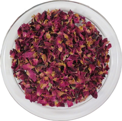 Draufsicht auf getrocknete, geschnittene Rosenblütenblätter in einer klaren Glasschale. Die fragmentierten Blütenblätter zeigen ein intensives Farbspiel aus tiefem Magenta und Rosa mit gekräuselter Textur.