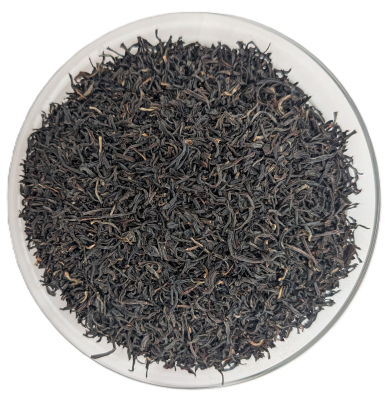 Tippy Assam Schwarztee – feines, eng gedrehtes, dunkelbraunes Teeblatt mit sichtbaren hellen Blattspitzen in einer Schale.
