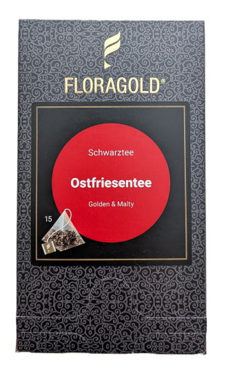 Eine dunkelgraue FLORAGOLD-Verpackung mit Ornamenten und goldenem Markenlogo oben. In der Mitte befindet sich ein auffälliger roter Kreis mit weißer Aufschrift: "Schwarztee", "Ostfriesentee" und "Golden & Malty". Unten links steht die Zahl "15" neben der