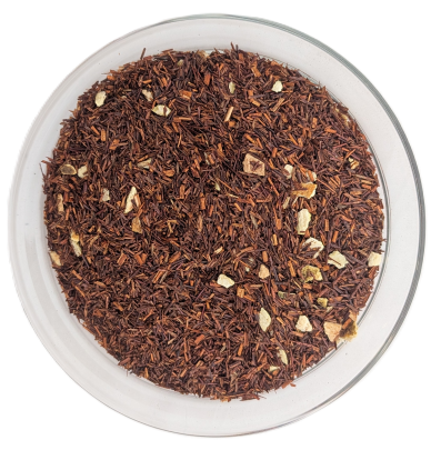Lose Rooibos-Tee-Mischung mit kleinen, gewürfelten Stücken getrockneter Orangenschale, präsentiert in einer runden Glasschale auf weißem Hintergrund.