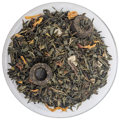 Grünteemischung mit kleinen gepressten Pu-Erh-Tee-Nestern und gelben Blütenblättern in einer Glasschale.