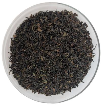 Bio Darjeeling First Flush Badamtam – Frühlingspflückung mit olivgrünen und dunklen Blattanteilen in einer Schale.
