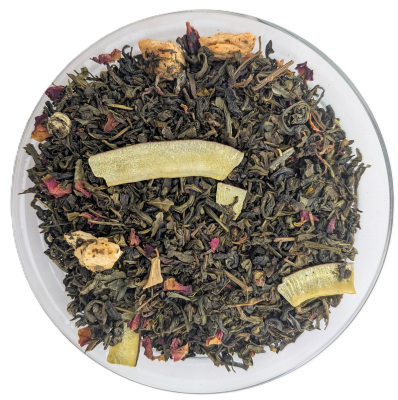 Grüner Tee mit Kokosstreifen, getrockneten Zitrusstücken und rosa Blütenblättern in einer Glasschale.