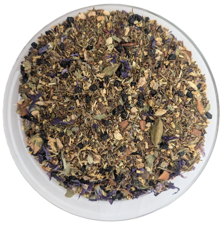 Nahaufnahme der Teemischung Holunderblüte mit Ingwer in einer klaren Schale, eine feine Mischung mit dunklen Holunderbeeren, violetten Blütenblättern und grünen Kardamomkapseln.
