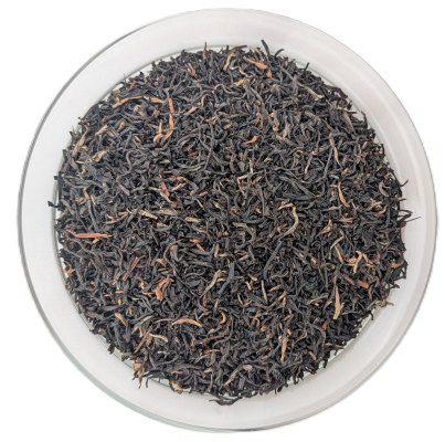 Assam Mokalbari STGFOP Schwarztee – feine, dunkelbraune Blattspitzen mit hellem Golden-Tip-Anteil in einer Schale von oben.