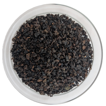 Stark oxidierte, sehr dunkelbraun bis schwarz gerollte Bio Ruby Oolong-Teeblätter in einer Schale.