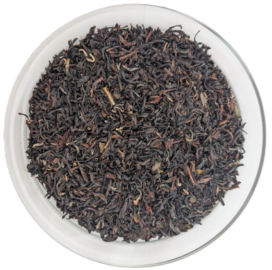 Bio Darjeeling Summer Gold Schwarztee – fein gedrehtes, dunkles Sommerpflückungs-Teeblatt in einer gläsernen Schale.