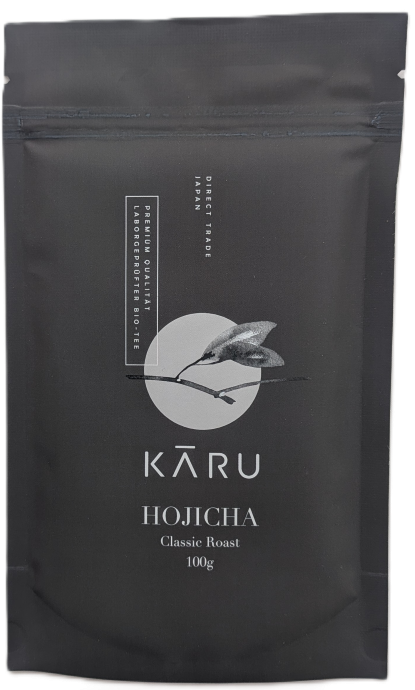 Schwarzer, wiederverschließbarer Standbodenbeutel mit Zipper des Bio Hojicha Pulvers Classic Roast von KARU (100g) auf hellem Hintergrund.