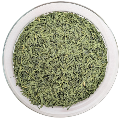 In einer rundem Glasschale liegt feiner, nadelartiger grüner Tee (Japan Sencha), der mit leuchtend grünem Matcha-Pulver verfeinert ist.